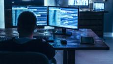 Dark monitors on a desk and more on a dresser Dark monitors on a desk and more on a dresser