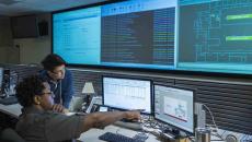 Worker pointing at screen with coworker