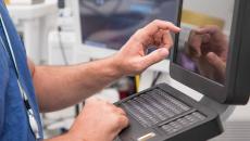 Healthcare worker using touchscreen computer terminal Healthcare worker using touchscreen computer terminal