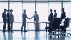 Business professionals shake hands to formalise a deal Business professionals shake hands to formalise a deal