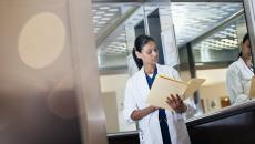 A doctor reviewing a paper patient record