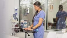 Healthcare worker using laptop in hospital room Healthcare worker using laptop in hospital room