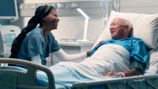 Healthcare worker talking to patient in hospital bed Healthcare worker talking to patient in hospital bed