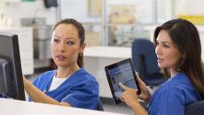 Nurses talking and pointing at device screens
