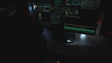 monitor on dark desktop shows multiple screens of data