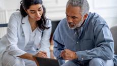 Doctor showing tablet to patient