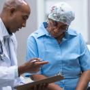 Doctor showing clipboard to cancer patient