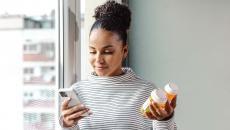 Smartphone user holding a pill bottle