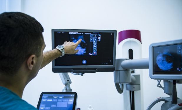 Healthcare worker pointing at x-ray image on monitor Healthcare worker pointing at x-ray image on monitor