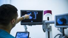 Healthcare worker pointing at x-ray image on monitor Healthcare worker pointing at x-ray image on monitor