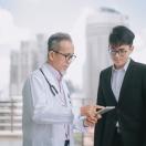 A doctor speaking with a person in a suit.