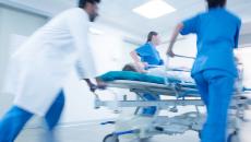 An emergency team pushing a patient on a gurney An emergency team pushing a patient on a gurney